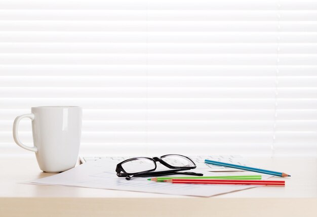 Office workplace with coffee supplies and reports