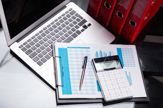 Office workplace with documents and stationery near red folders