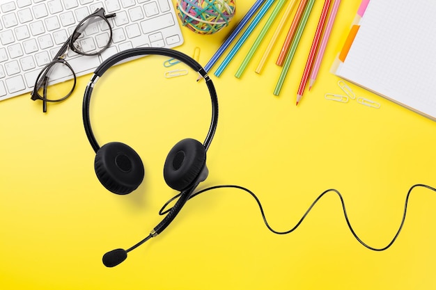 Photo office yellow backdrop with supplies and headset