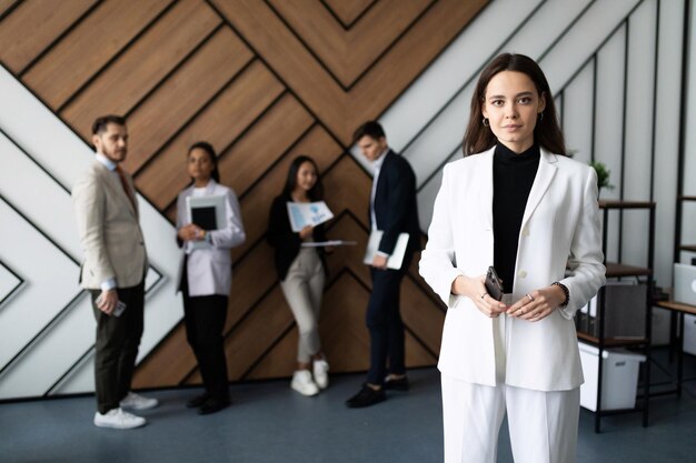 Foto officemanager tegen de achtergrond van werknemers die wachten op een interview op kantoor