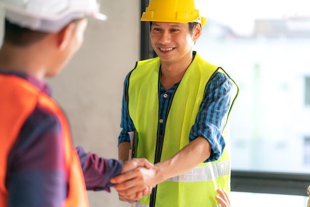 Officer teamwork is happy and shake hands to celebrate in success home building construction