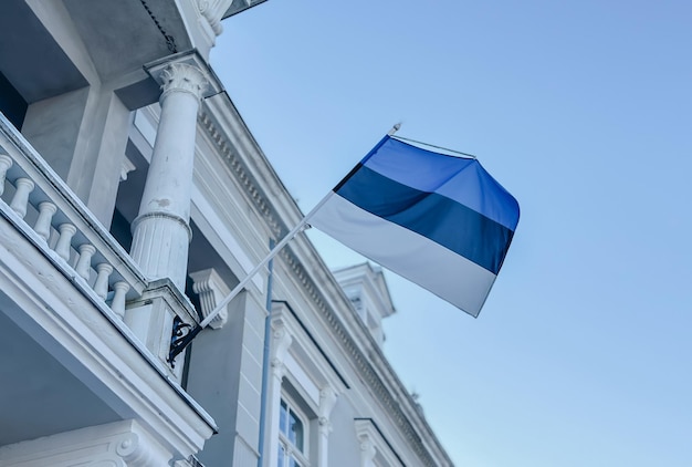 The official state symbol of estonia is a flag with a blue black and white stripe against a blue sky