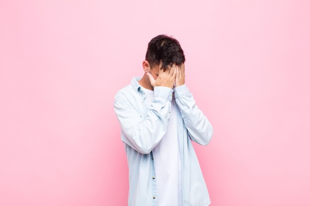 ogen bedekken met handen met een droevige, gefrustreerde blik van wanhoop, huilen