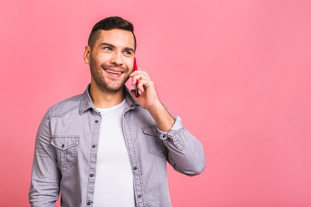 ああ、素晴らしいニュース携帯電話で話している若いカジュアルな男性の笑顔。電話を使う。