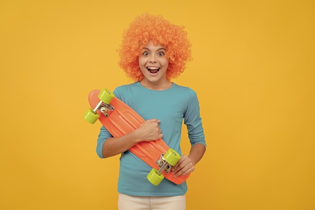 Oh my god fancy party look kid in clown wig hold penny board funny child with fancy hair