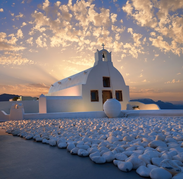 Oia village, Santorini island in Greece. Chapel on sunrise with white stones