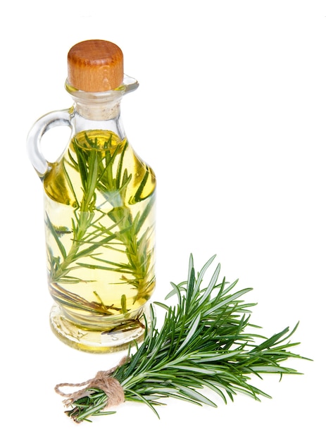 Olio in una bottiglia e rosmarino organico fresco isolato su bianco