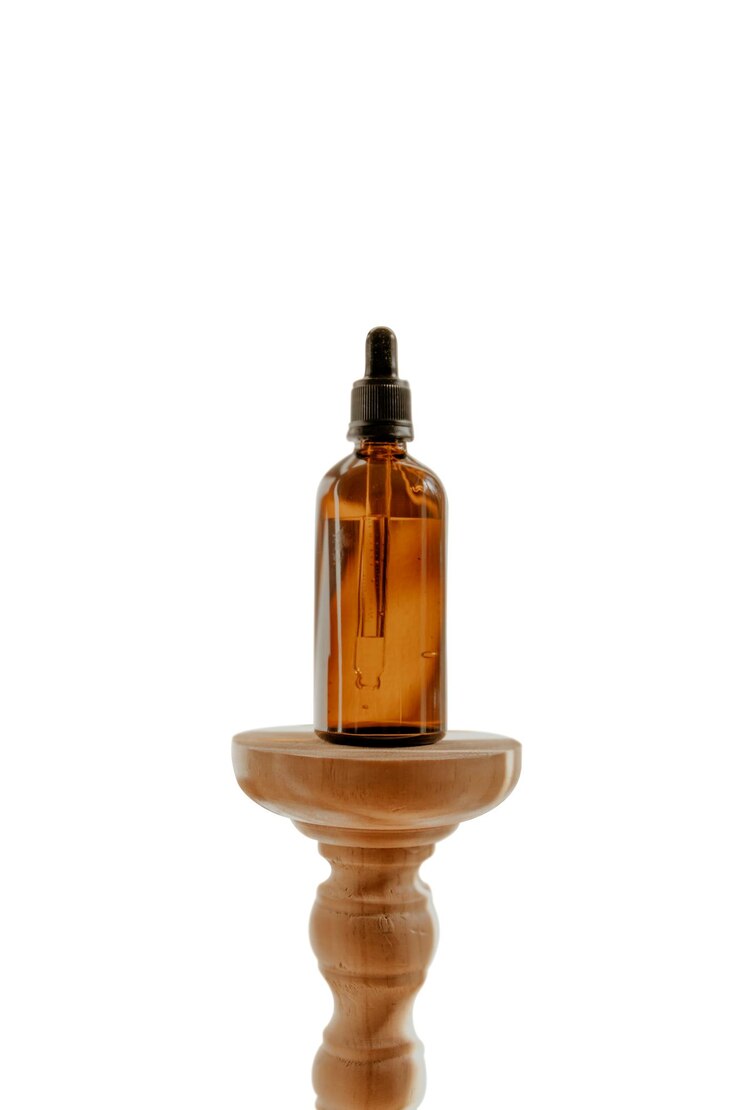 Photo oil bottle with dropper on base isolated on white background