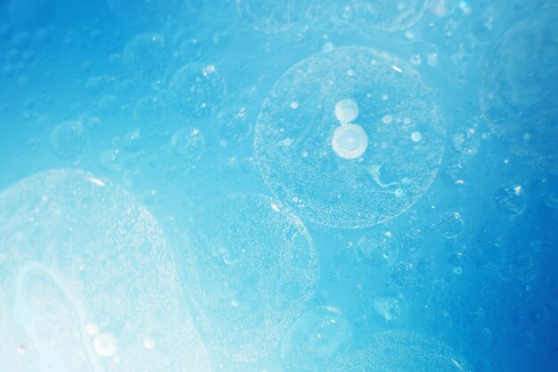 Oil bubbles close up circles of water macro abstract light blue background