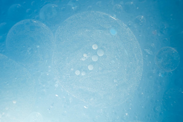 Oil bubbles close up circles of water macro abstract light blue background