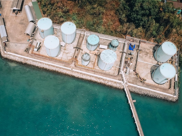 海岸の石油貯蔵所ターミナル、長い石油パイプ、鋼製コンテナ、空中写真。技術の概念。