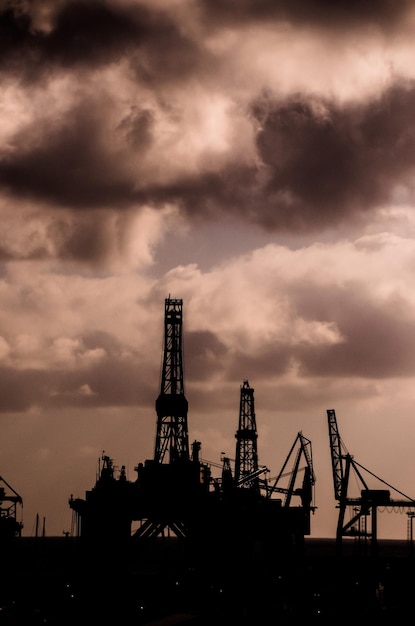 Oil Drilling Rig Silhouette over a Cloudy Sky