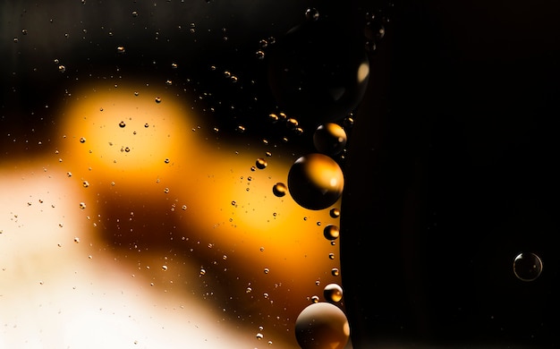 Oil drops on a black water surface abstract background