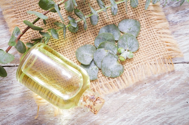 Oil and eucalyptus leaves on the wooden table