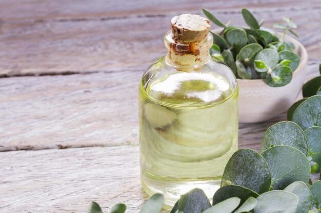 Oil and eucalyptus leaves on the wooden table