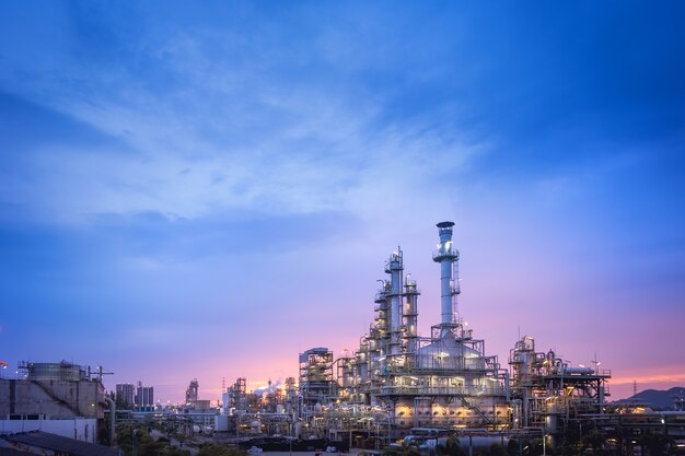 Foto impianto di raffineria di petrolio e gas o industria petrolchimica sul tramonto del cielo blu