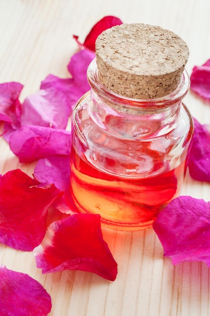 Olio in bottiglia di vetro e petali di rosa