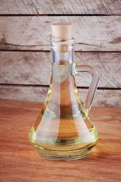 oil in glass jug on wooden background