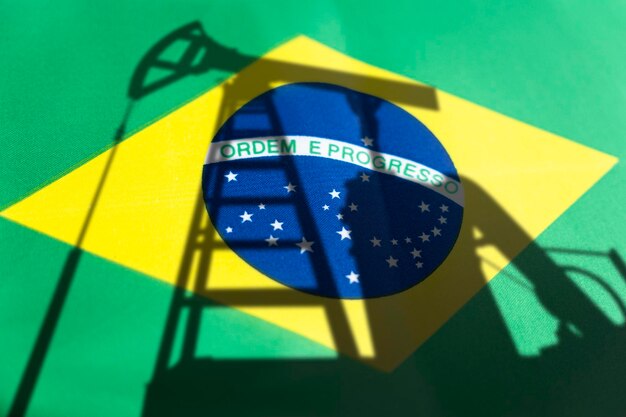 Нефтяная промышленность Бразилии Нефтяные вышки на фоне бразильского флага Добыча полезных ископаемых и экспорт нефти на мировом рынке топлива Концепция топливной промышленности
