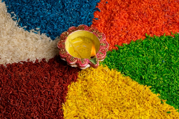 Oil lamps lit on colorful rangoli or rice during diwali celebration