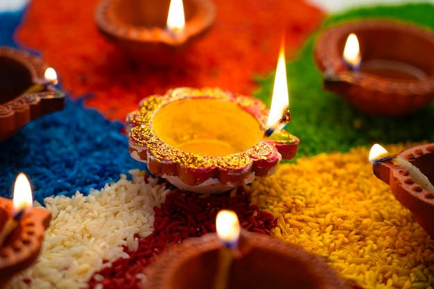 Oil lamps lit on colorful rangoli or rice during diwali celebration