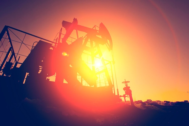 Oil pump on background of red orange sky