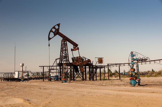 Oil pump jack and wellheads. Extraction of oil.