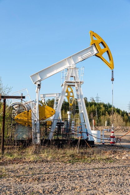オイルポンプリグ。石油とガスの生産。油田サイト。ポンプジャックが作動しています。化石燃料の生産と原油生産のための掘削デリック。石油価格との戦い。世界的なコロナウイルスCOVID19の危機。