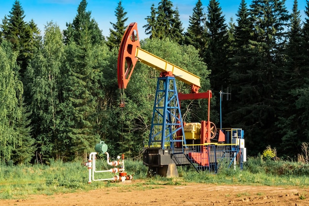 Oil pumping stations pumpjacks in a clearing in the forest