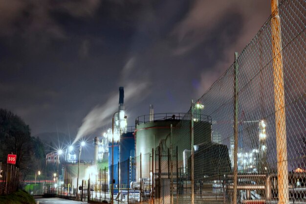 喫煙しながら石油精製所の夜景を眺める