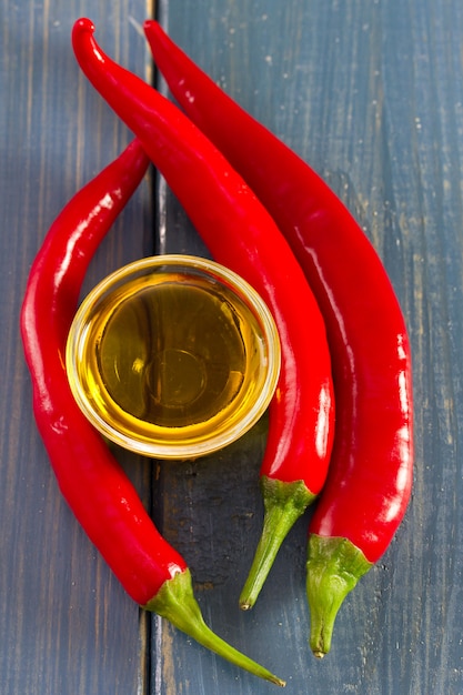 Oil and red pepper on blue wooden