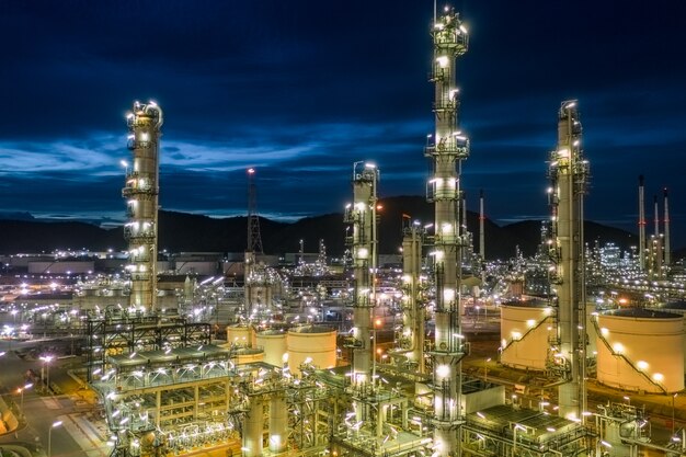 Oil refinery and gas petrochemical industry with storage tanks steel  pipeline area at twilight aerial view