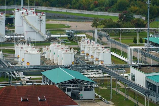 Oil storage facility on the territory of the city Oil refinery and chemical production Large iron barrels with petroleum products near the city park and green forest