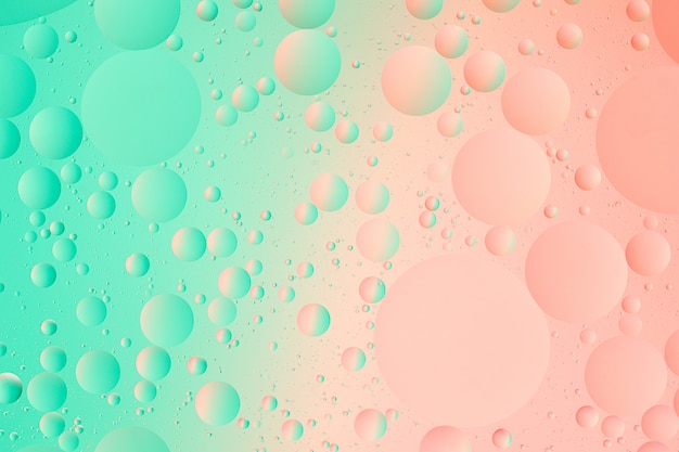 抽象的な緑とピンク色のグラデーションの背景の水マクロ写真の油