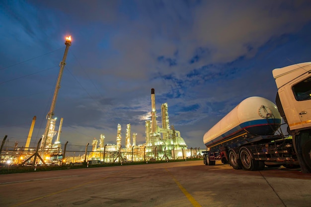 Oilâ refineryâ andâ plant and tower flare fire of
petrochemistry in âindustry transportation truck dangerous oil
gas truck tank is parked in the factory.