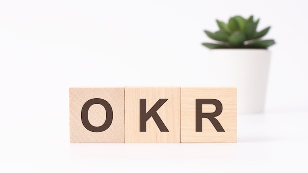 OKR-doelstellingen en belangrijkste resultaten acroniem op houten kubussen op witte achtergrond bedrijfsconcept