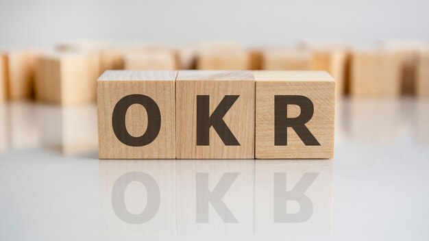 OKR word is made of wooden building blocks lying on the gray table, concept