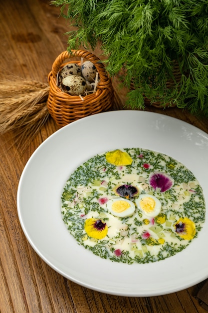 Okroshka with greens radishes boiled eggs on a wooden table
