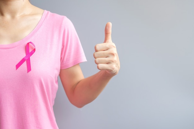 Oktober Breast Cancer Awareness-maand, oudere vrouw in roze T-shirt met roze lint en duimteken voor het ondersteunen van mensen die leven en ziekte. Internationaal vrouwen-, moeder- en wereldkankerdagconcept