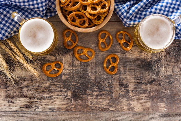 Photo oktoberfest beer and pretzel on wooden table.