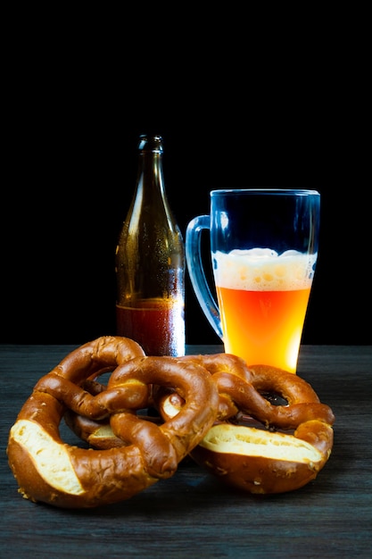 oktoberfest bierkruik en fles met pretzels donkere voedselachtergrond styl