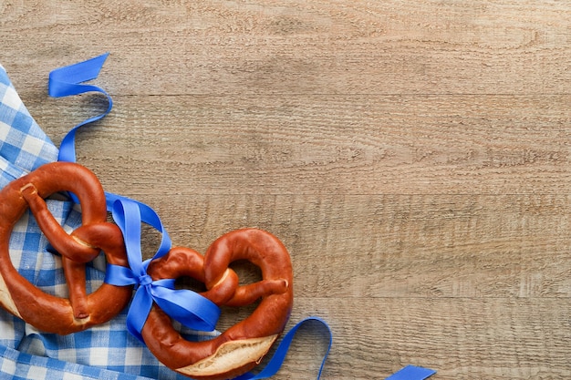 Oktoberfest concept card Traditional Bavarian pretzels with beer bottle mug on old rustic wooden background Perfect for Octoberfest Oktoberfest food menu Top view Mock up