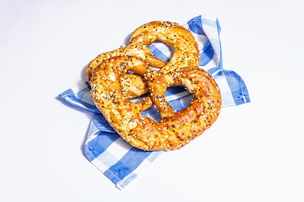 Oktoberfest concept - pretzels op een traditionele servet geïsoleerd op een witte achtergrond. Een trendy hard licht, donkere schaduw