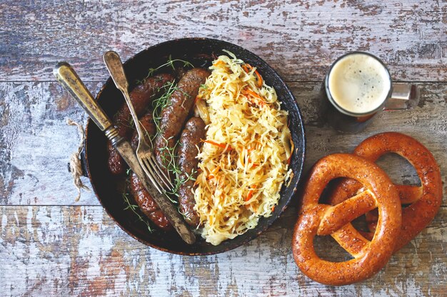 Oktoberfest food. Hot Bavarian sausages with sauerkraut in a pan. Delicious beer festival food