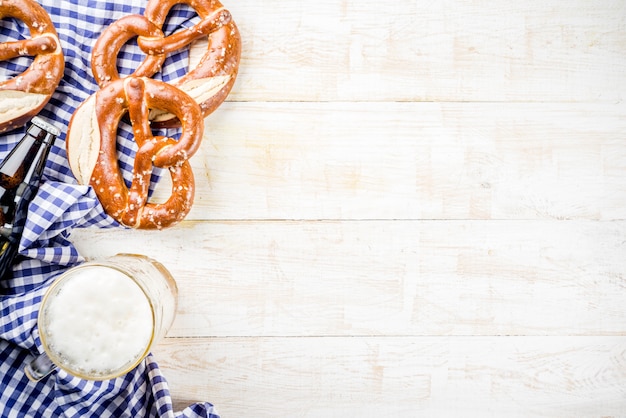 Photo oktoberfest food menu, bavarian pretzels with beer bottle mug, white wooden background