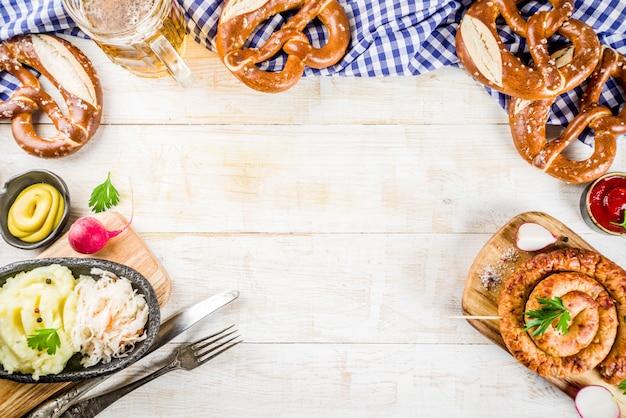 Photo oktoberfest food menu, bavarian sausages with pretzels, mashed potato, sauerkraut, beer bottle and mug