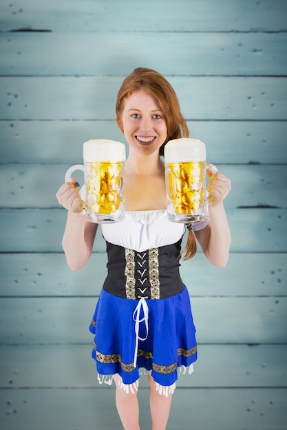 Photo oktoberfest girl holding jugs of beer against wooden planks