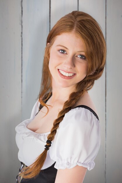 Oktoberfest girl smiling at camera against painted blue wooden planks