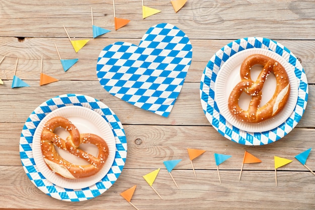 Oktoberfest rustic wall with prezel in paper plate and paper flags