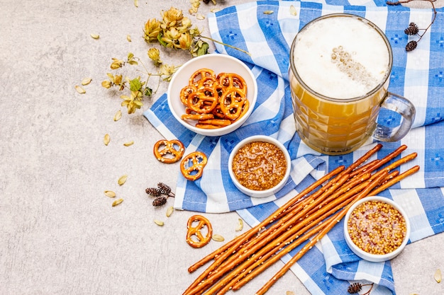 Foto set dell'oktoberfest. birra chiara, salatini, senape, paglia di sesamo, luppolo.